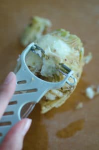 A peeler peeling the outer layer of the celeriac root.