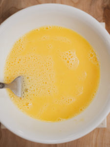 Anna's mixing raw eggs for the savory oatmeal recipe