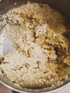 A close up look of cooked savory oatmeal with cooked egg in the savory oatmeal recipe