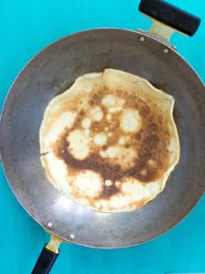 A crêpe reheating in a wok