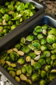 Overhead view of baking pans filled with brussels sprouts. Recipe from garlicdelight.com.