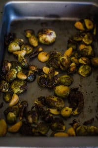 Overhead view of darkly roasted brussels sprouts in baking pans. Recipe from garlicdelight.com.