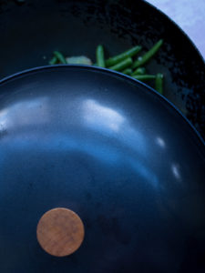 Lid over a wok with green beans