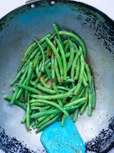 Stir fry of green beans with chili sauce in wok