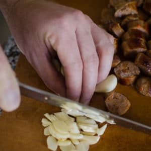 Close up shot of Alex chopping garlic. Jambalaya Recipe from garlicdelight.com.