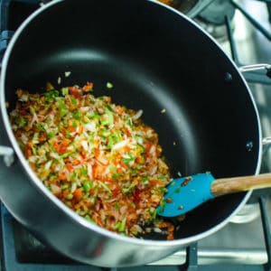 Close up shot of stirring holy trinity in pot. Jambalaya Recipe from garlicdelight.com.