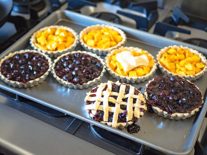 Mango and cherry tarts fresh out of the oven with golden crusts