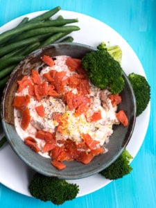 Smoked salmon and cream cheese dip in green bowl with broccoli and green beans