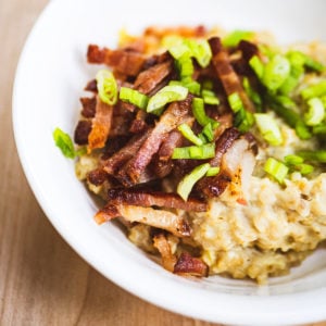 Savory oatmeal with egg topped with bacon and sliced green onions