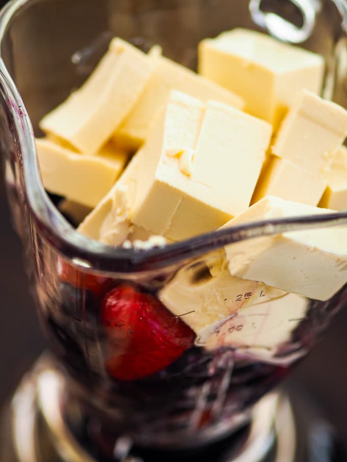 Tall blender with glass jar, tofu and frozen berries in the glass jar