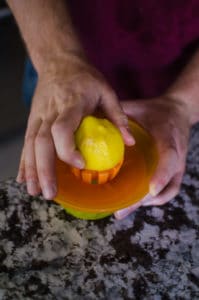 Overhead shot of squeezing lemon. Recipe from garlicdelight.com.