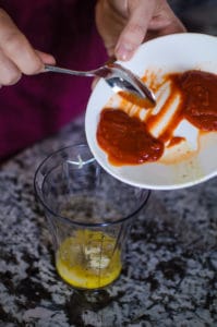 Overhead shot of adding Sriracha. Recipe from garlicdelight.com.