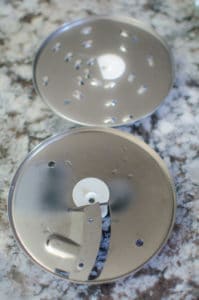 Overhead shot of 2 food processor blades. Recipe from garlicdelight.com.