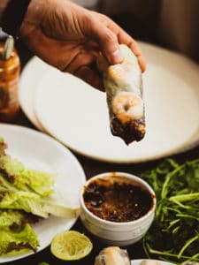 Vietnamese spring rolls dipped into peanut butter sauce